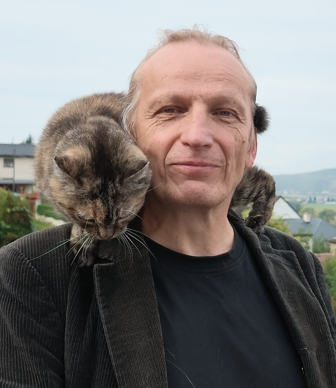 Petr Samojský s kočkami na ramenou